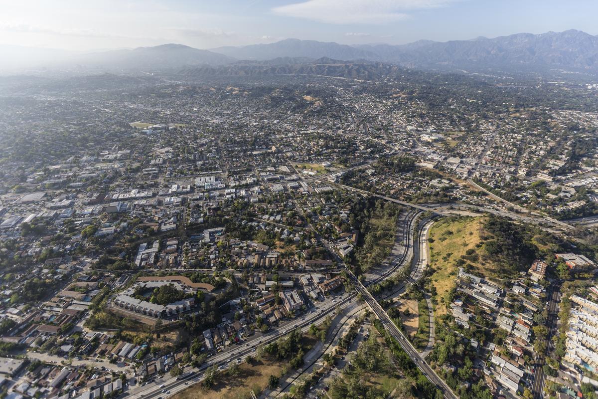 Modern building exterior with trees and parked cars in Highland Park.